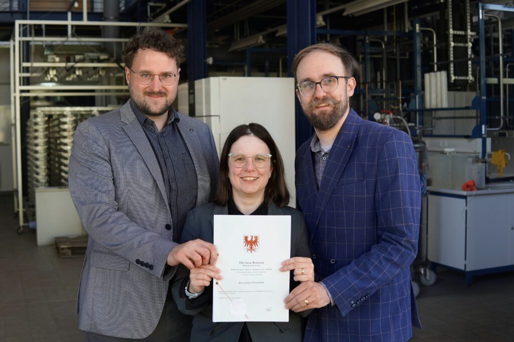 Das Gründerteam mit Ukrunde in der Hand.